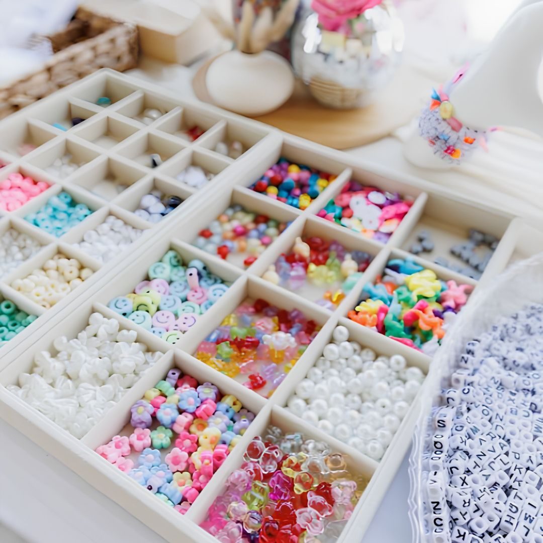 A compartment tray of beads, letters and charms ready for a Charm Bar