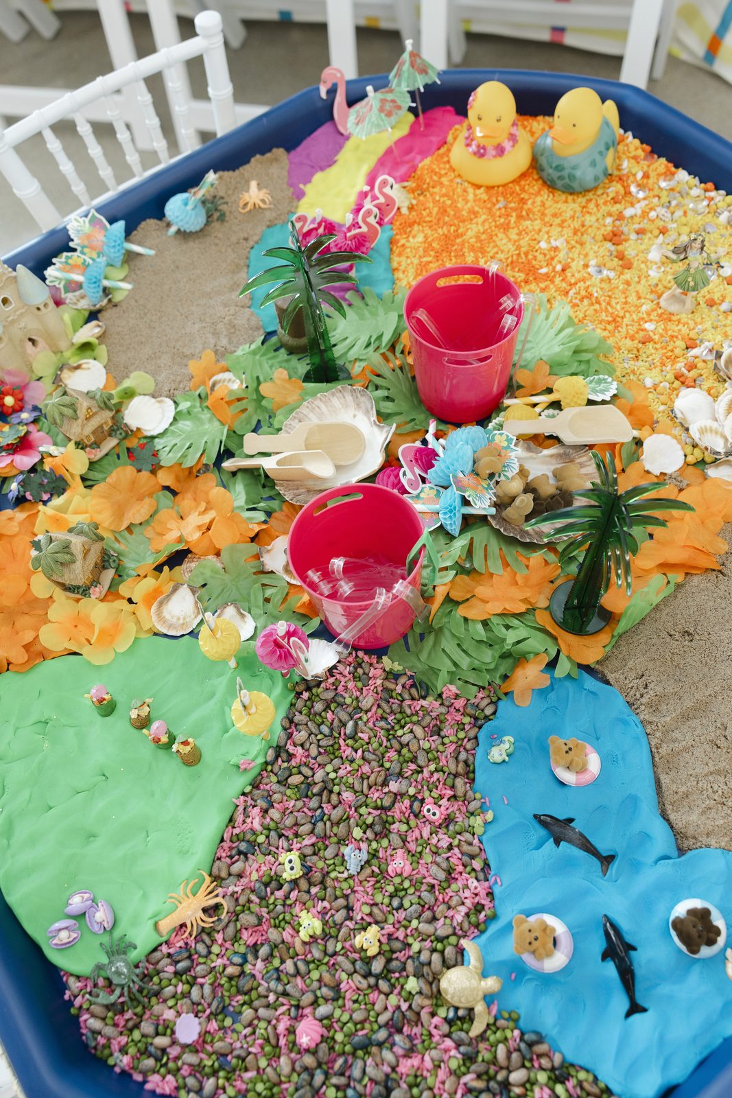 A sensory tray built with sand, shells, gravel and sea creatures